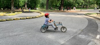 Enfant avec casque rouge sur un tricycle bleu